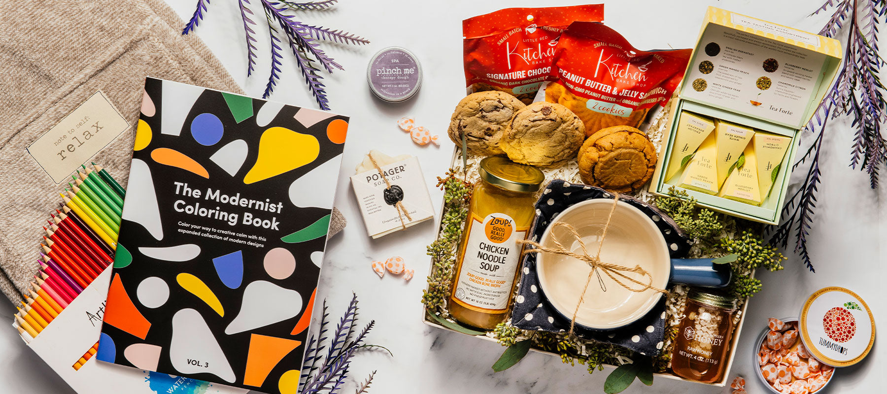Luxury get well gift box featuring an adult coloring book with colored pencils, comforting chicken soup, a soft pashmina, handmade soap, tea, cookies, and thoughtfully curated wellness items.