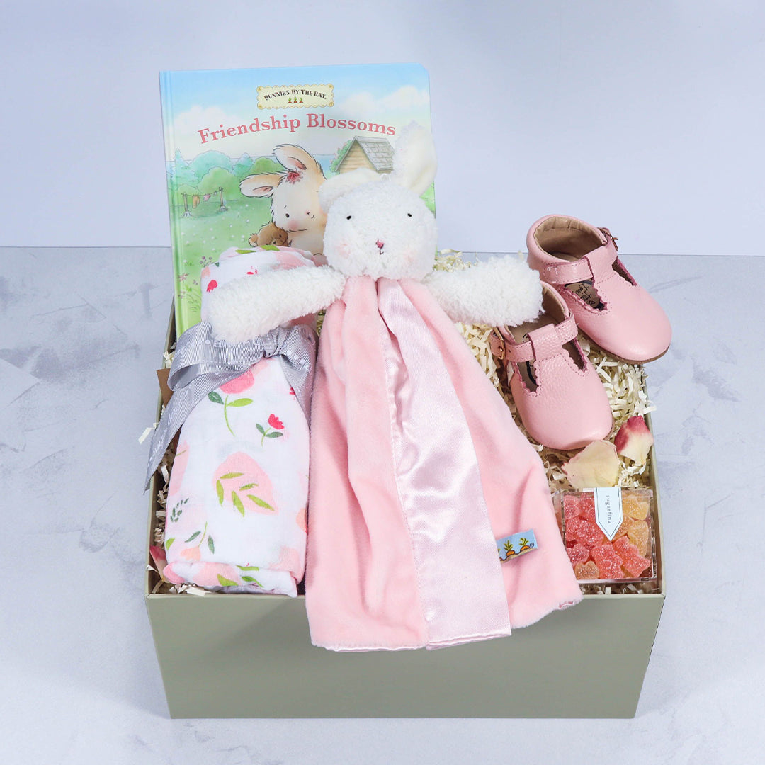 Girls baby gift box featuring a Bunny by the Bay lovey and swaddle, Sugarfina candy, leather baby shoes, and thoughtfully curated newborn essentials.