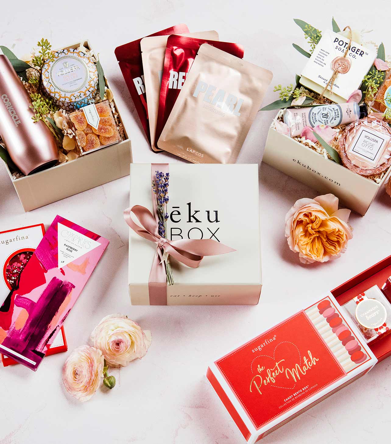a grouping of Valentine's Day gift boxes with ribbons and flowers,