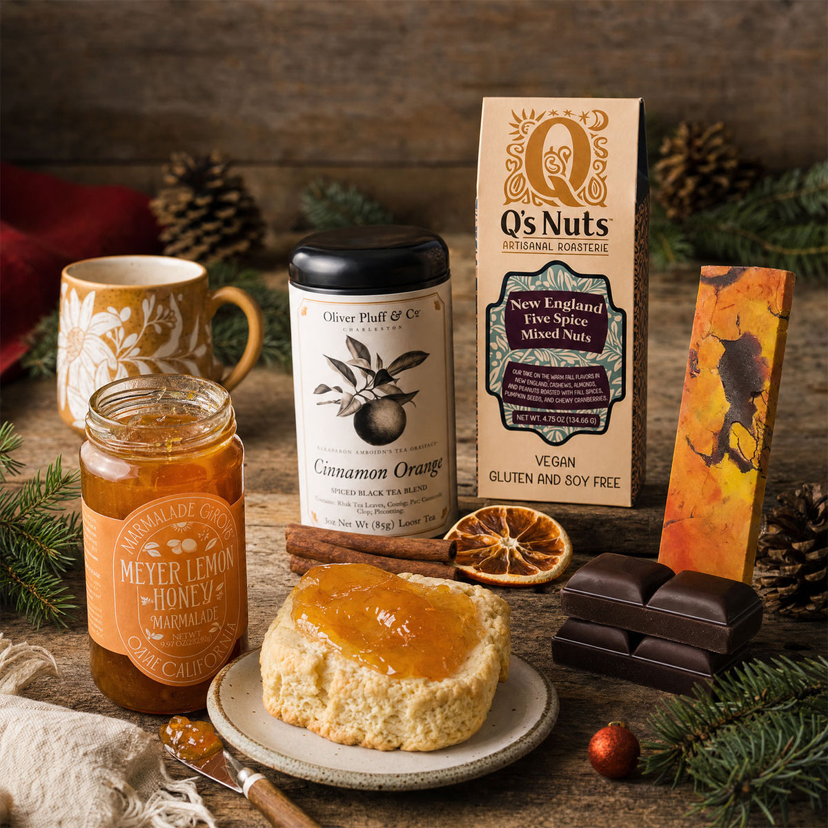 MEYER LEMON HONEY MARMALADE, ON A SCONE, CINNAMON ORANGE TEA, A PACKAGE OF GOURMET NUTS, A CHOCOLATE ORANGE CHOCOLATE BAR AND A CUP WITH SUNFLOWERS - ALL ON A TABLE WITH A RUSTIC BACKGROUND