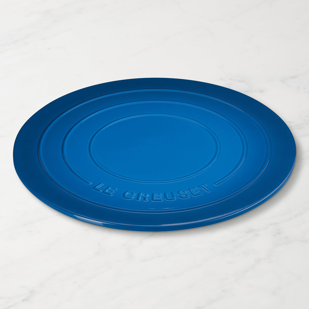 Marseille pizza stone with 'Le Creuset' branding on a white marble surface