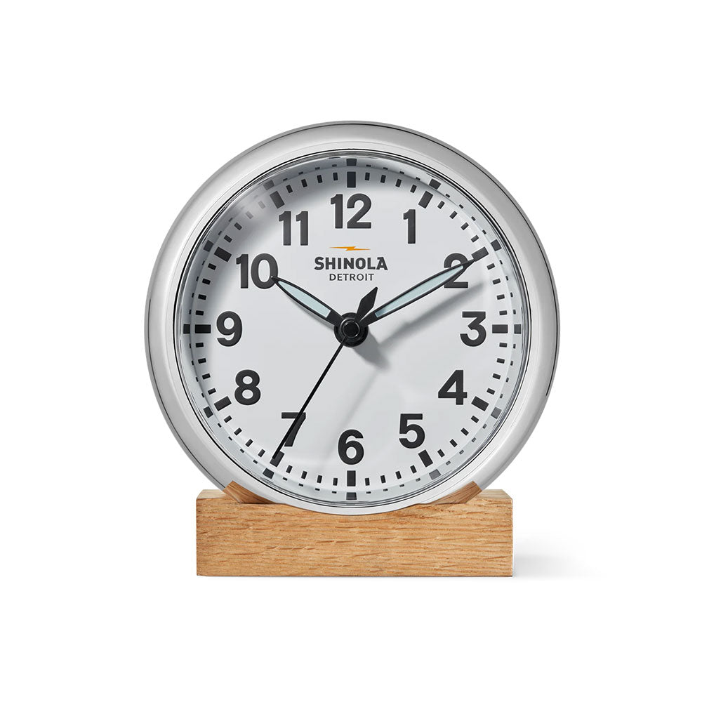Shinola clock with wooden base on a white background