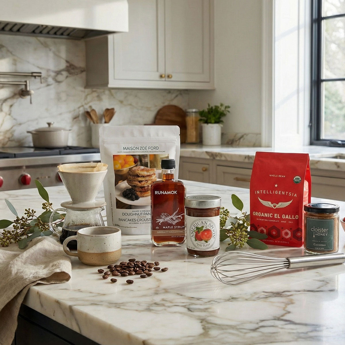 Kitchen counter with coffee, pancake mix, jam, syrup, and a jar of honey on a marble countertop.