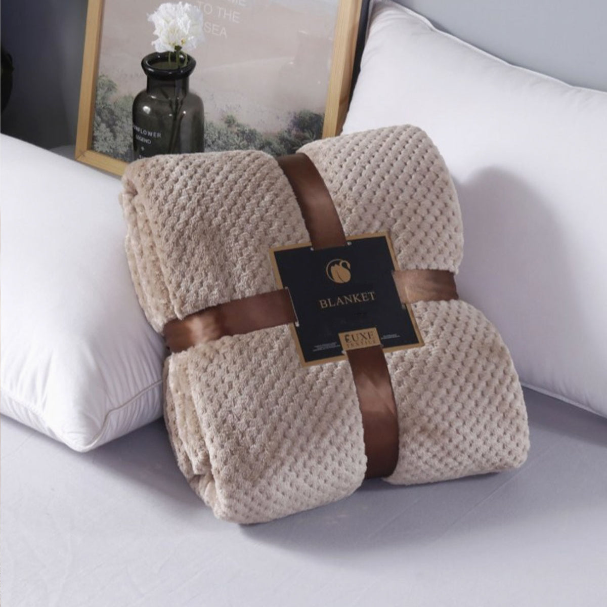 brown blanket tied with ribbon sitting next to pillows