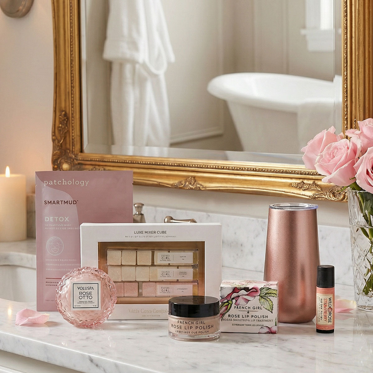 flute glass, lip balm, lip scrub, macaron candle, mimosa sugar cube kit, face mask in bathroom setting.