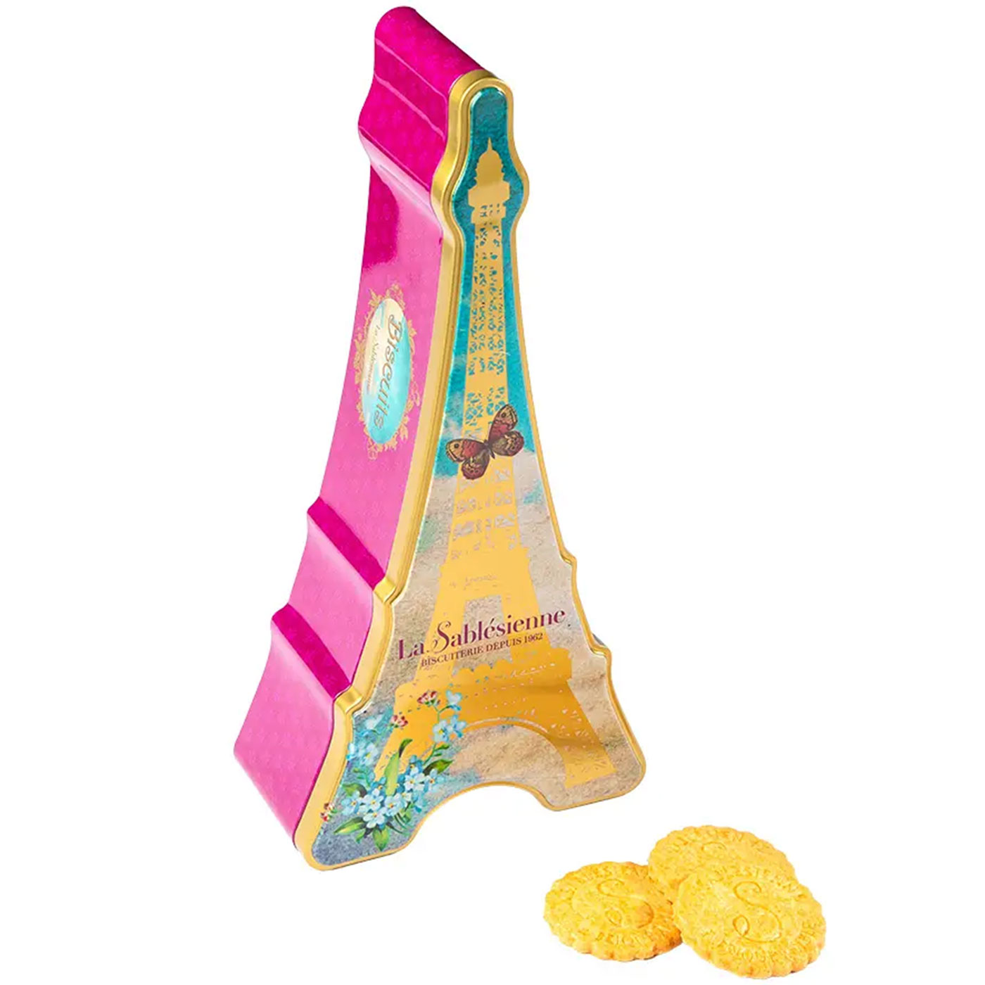 A pink and gold Eiffel Tower-shaped tin of La Sablesième cookies, with three round yellow cookies placed in front on a plain white background.
