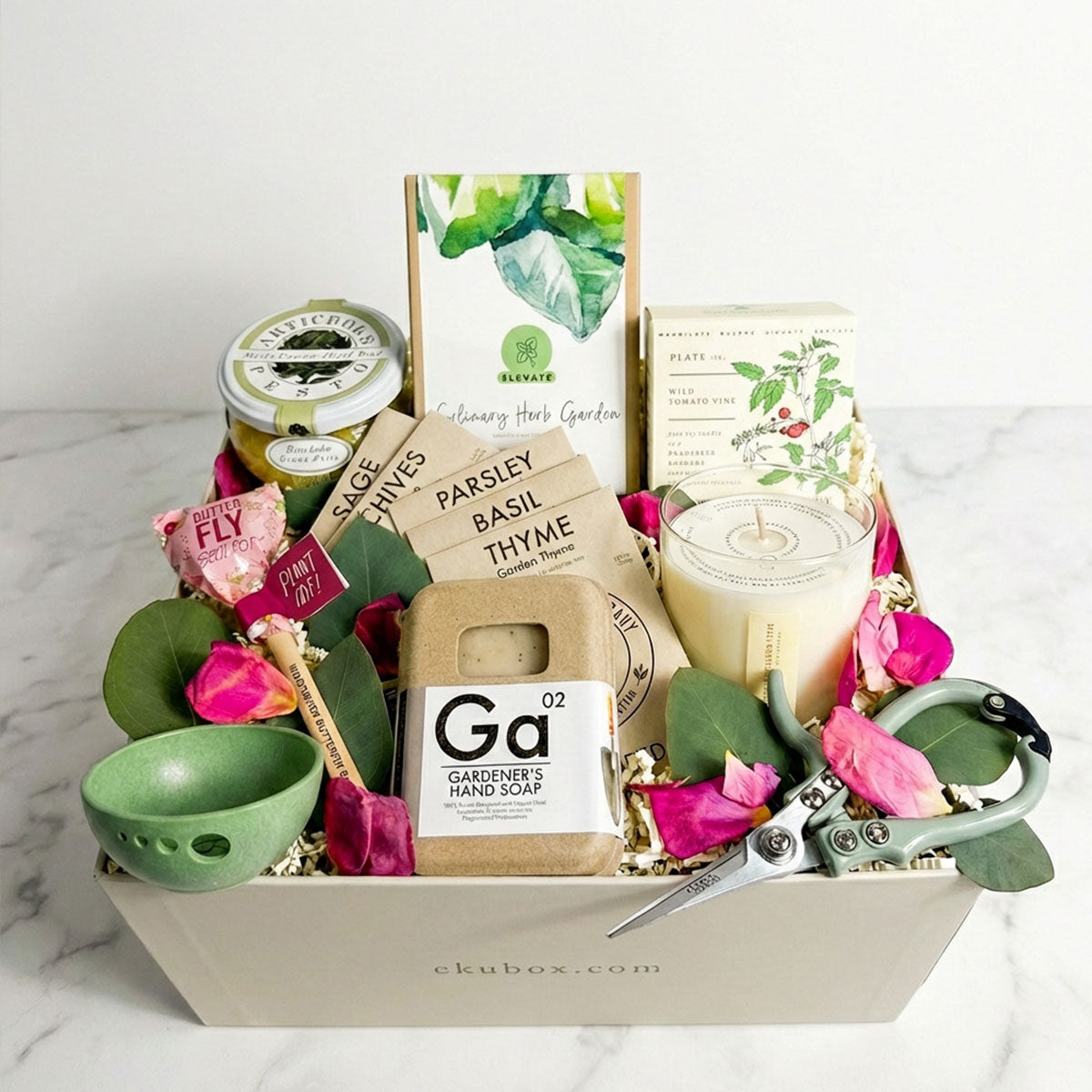 small gardening gift set in a signature ekuBOX with seed packets, pesto sauce, candle, seed pop, garden shears, and dried rose petals.