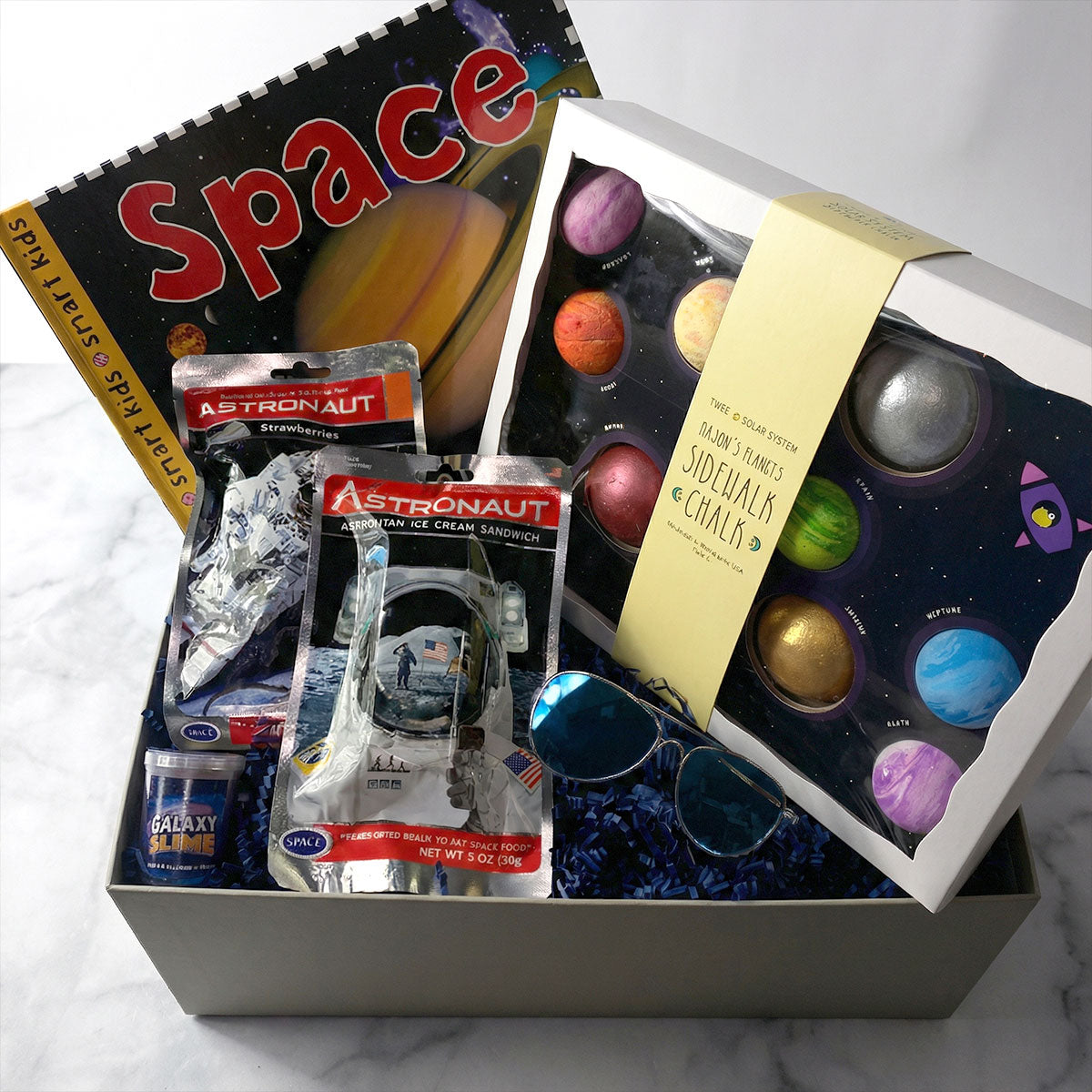 Space-themed gift box for kids with astronaut-themed items and astronaut snacks.