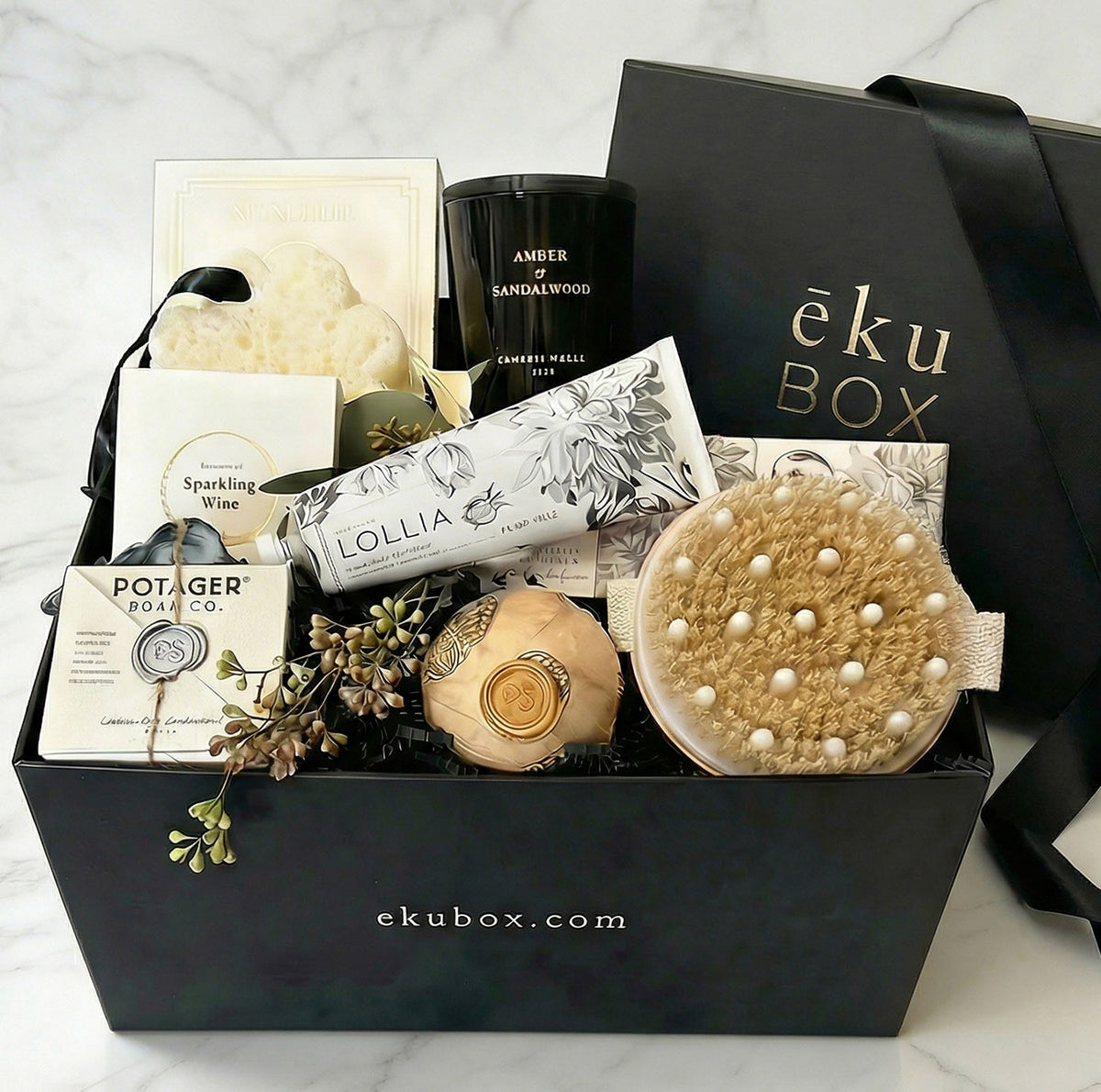 luxury ready-to-ship spa gift set with candle, soaps, body brush, in black box on marble table top.