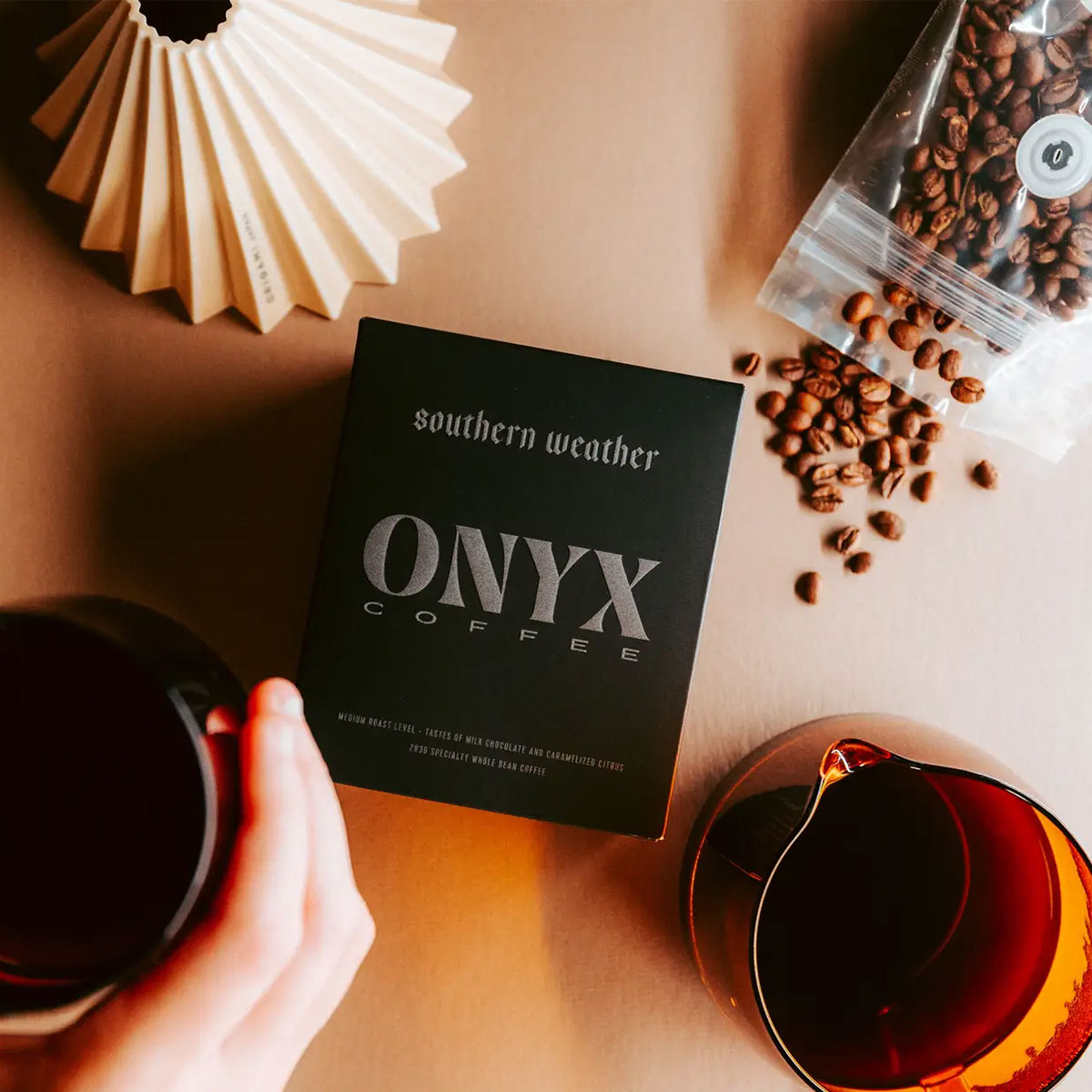 Onyx Coffee package with coffee beans and a mug on a wooden surface