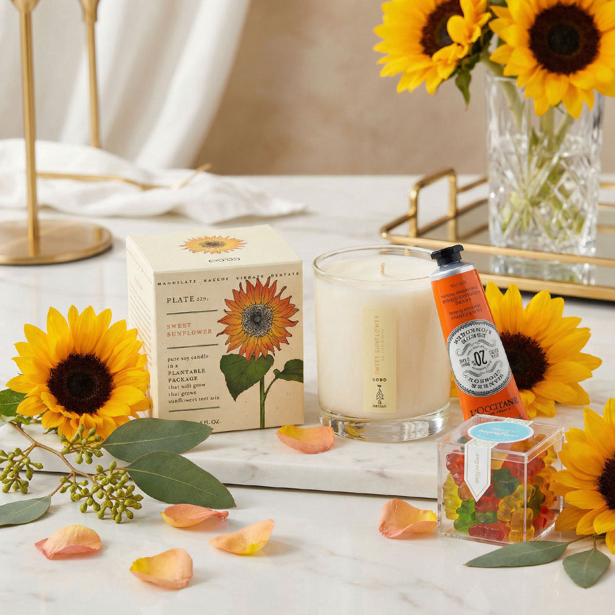 sunflower candle, handcream, sugarfina candy on marble table and fresh sunflowers