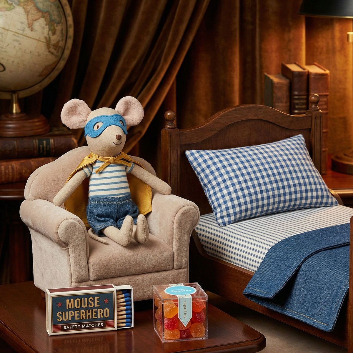 Maileg Stuffed mouse in superhero costume sitting on a chair with books and globe in the background