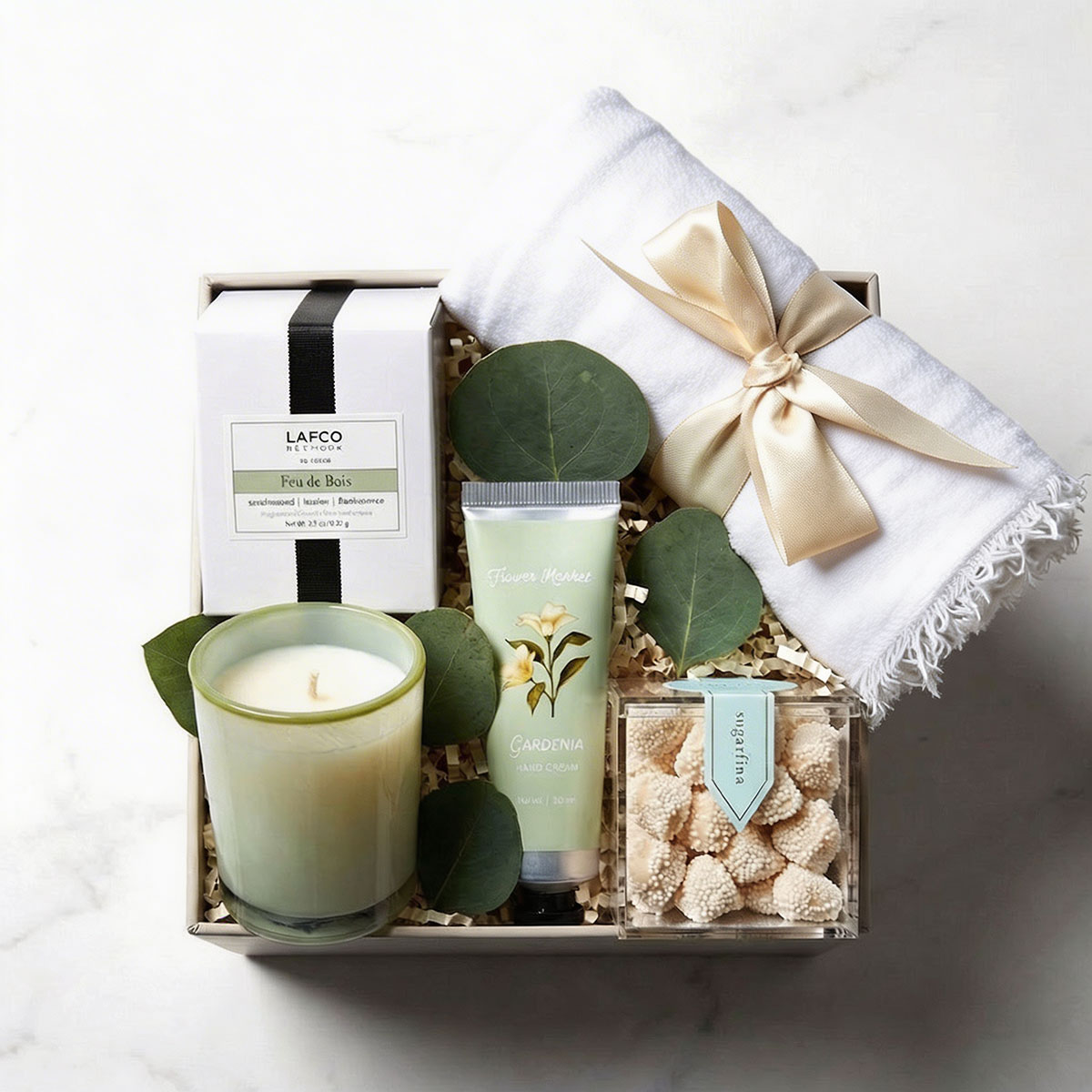 Gift set with Lafco candle, hand cream, and cookies in a box on a white background