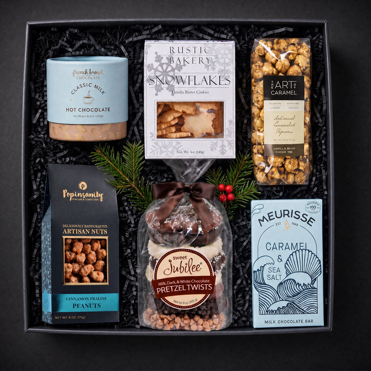 gift box filled with classic milk hot chocolate, rustic bakery butter cookies, artisan popcorn, candied peanuts, Chocolate covered pretzels and a caramel chocoalte bar