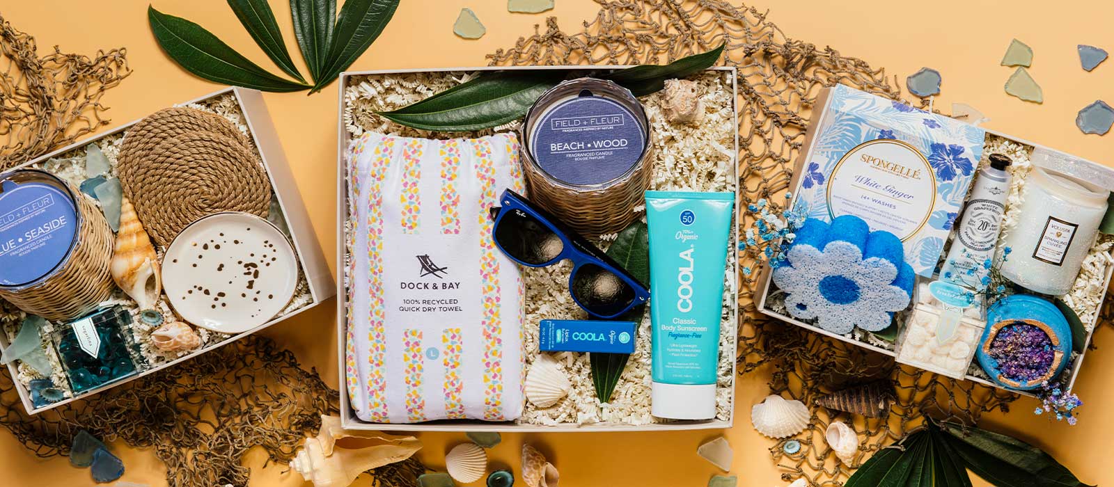 A curated display of colorful summer gift boxes on an orange background, featuring seasonal essentials for summer gifting.