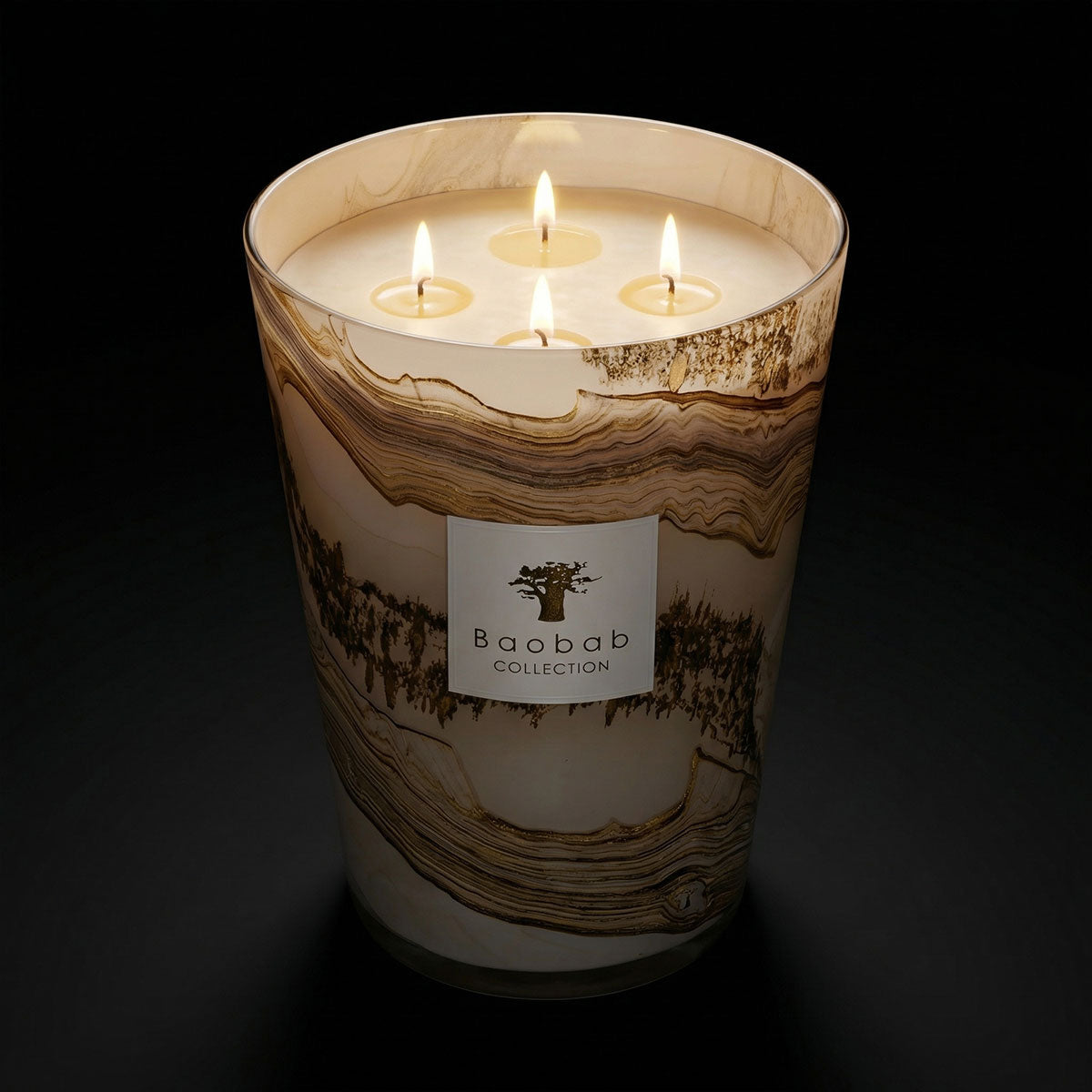 Lit candle from the Baobab Sand Collection' label on a dark background
