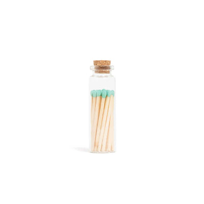 Glass bottle with cork lid containing matches on a white background