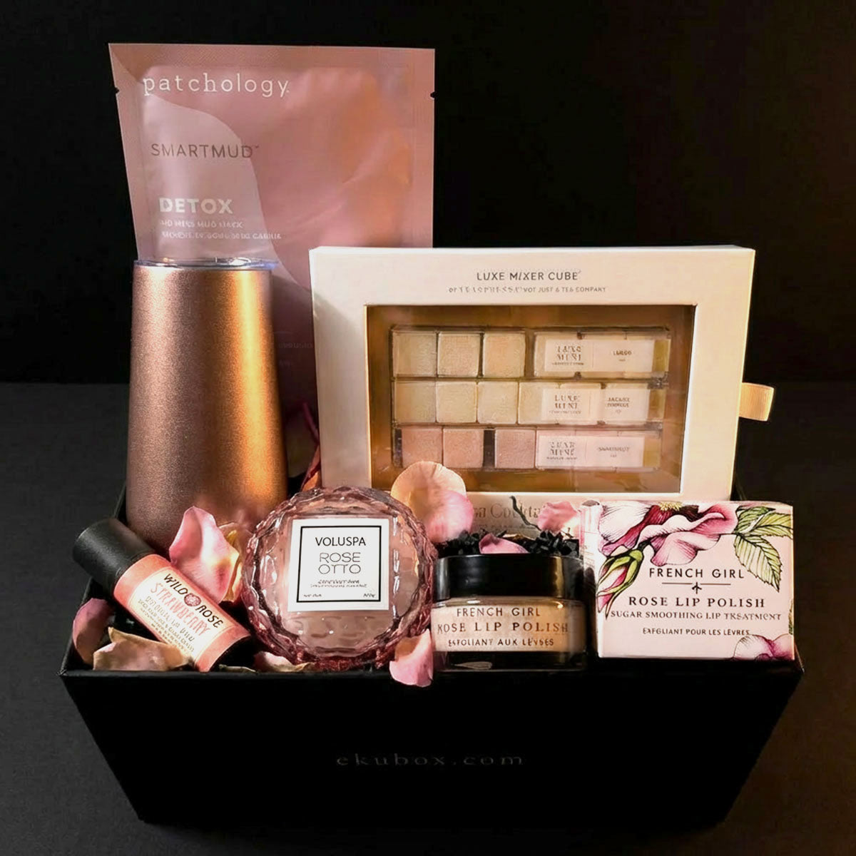 spa gift box with Skincare and beauty products in a box, along with a mimosa kit and a stemless thermal champagne flute on a black background