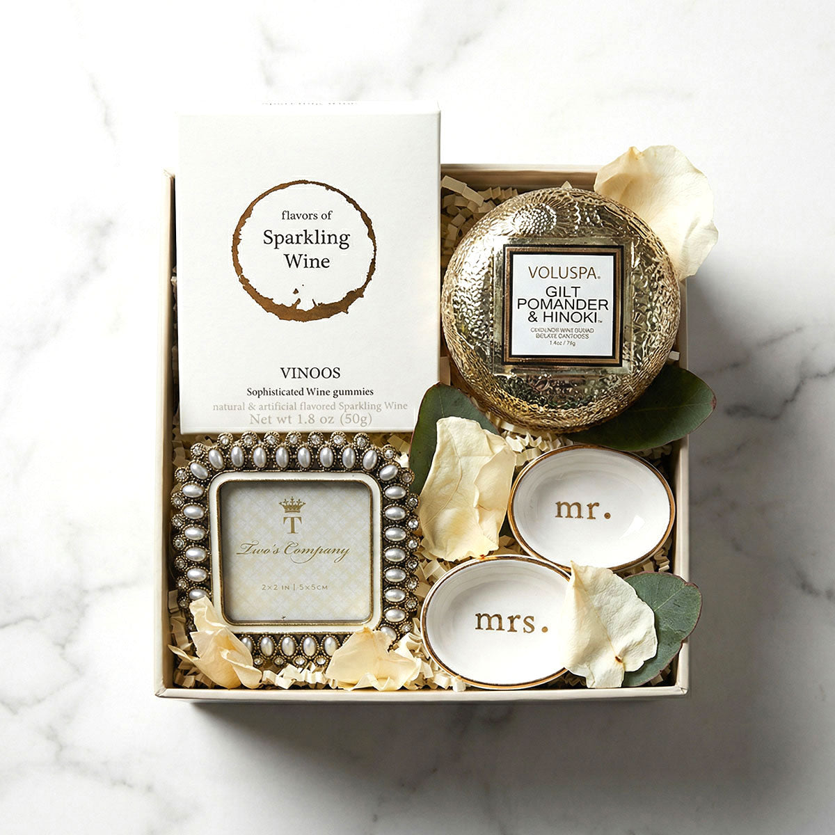 box of gummies, mini frame, gold glass candle and mr and mrs tiny dishes in a gift box