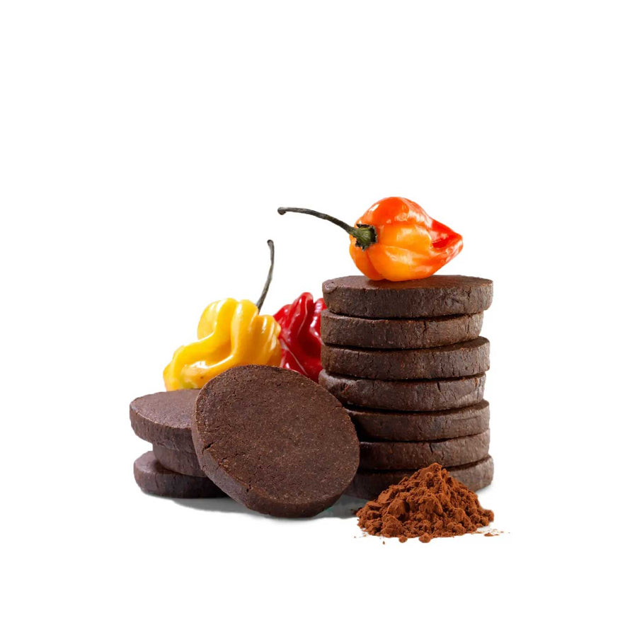 Stack of dark brown chocolate cookies with colorful peppers on a white background