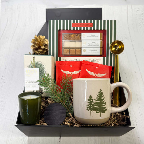 Gift set with mug, candle, and tea, and flavored sugar cubes in a gift box 包 on a white surface