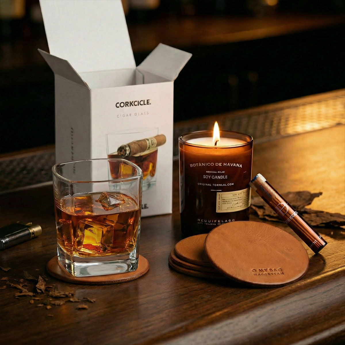 Candle, glass of whiskey, toothpicks, leather coasters, and a Corkcicle box on a wooden surface.