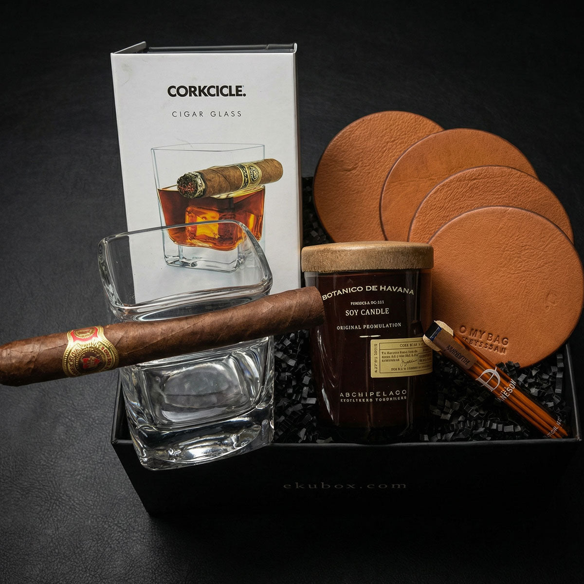 luxury whiskey and cigar gift box containing a Corkcicle cigar glass, candle, four leather coasters, and infused toothpicks in a black gift box.