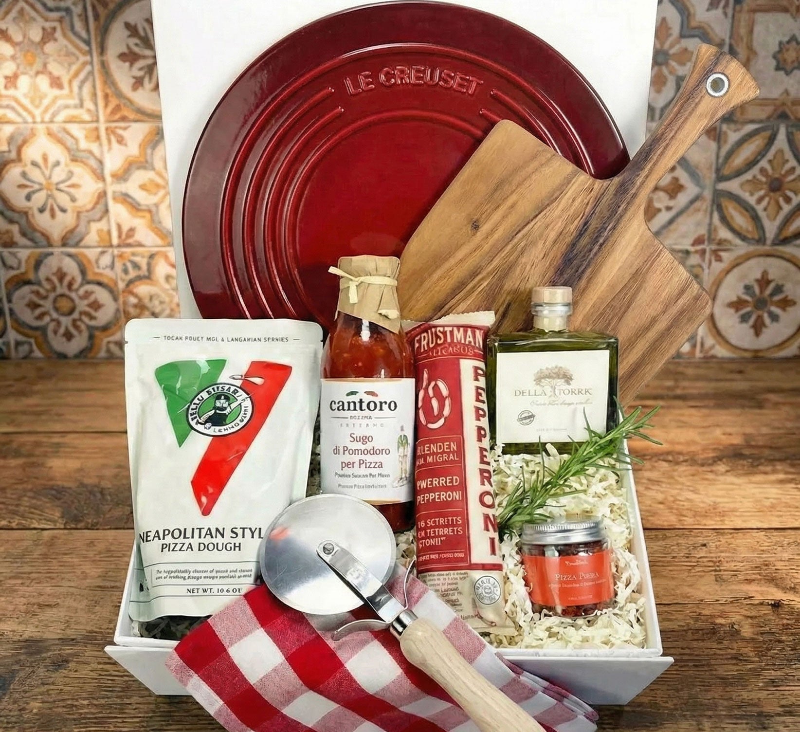 pizza night gift box featuring Le Creuset Pizza Stone and pizza paddle with pizza making ingredients. 