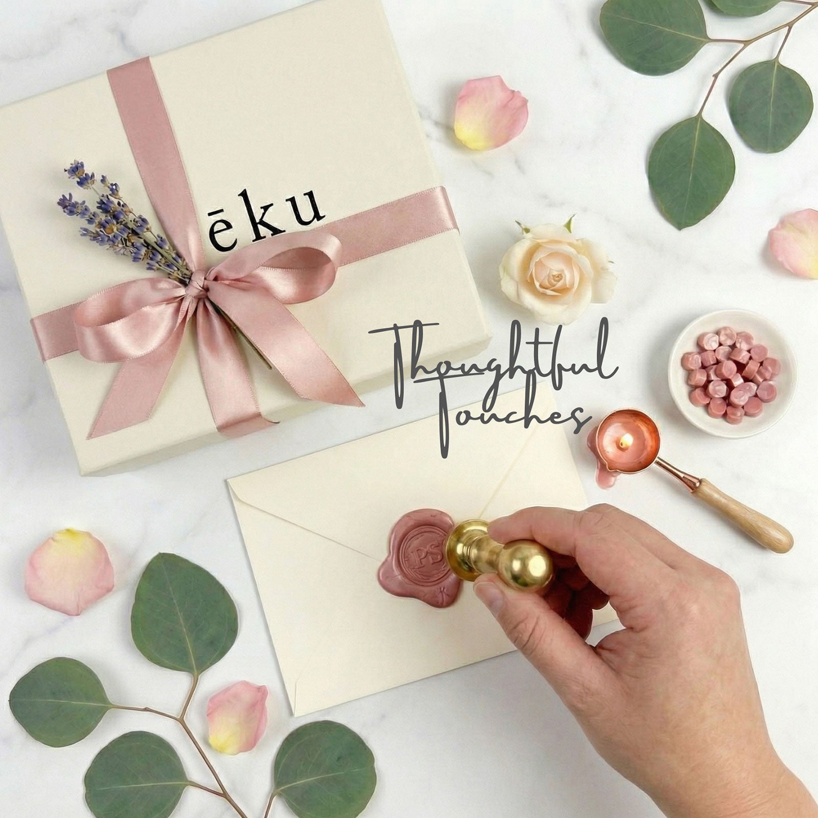 Luxury Gift box with pink ribbon, envelope with wax seal, and roses on a light surface.