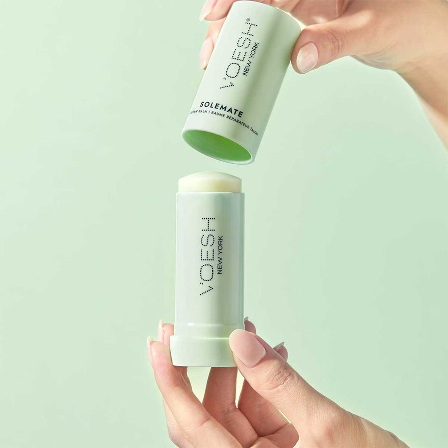 Two VOESH New York foot care products held against a light green background