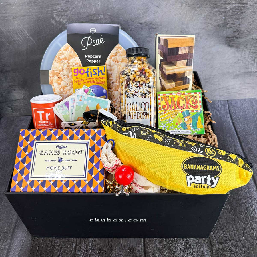 Gift box with games, snacks, and a popcorn popper on a wooden surface. Great Group Gift | ekubox