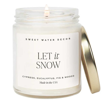 Candle in a glass jar with a gold lid labeled &