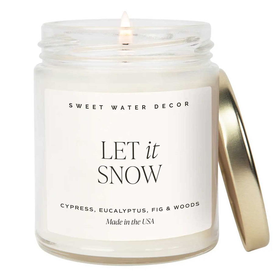 Candle in a glass jar with a gold lid labeled &