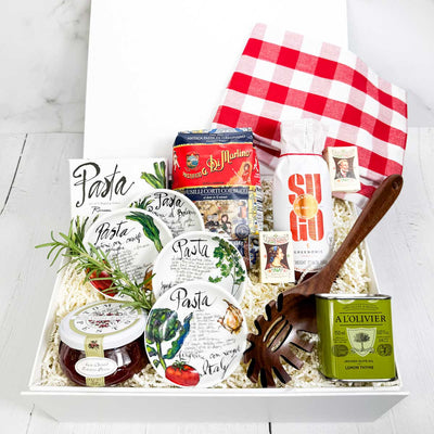 ekuBOX gift box with Italian-themed products including pasta and olive oil, pasta sauce, dipping dishes and a pasta spoon on a white background
