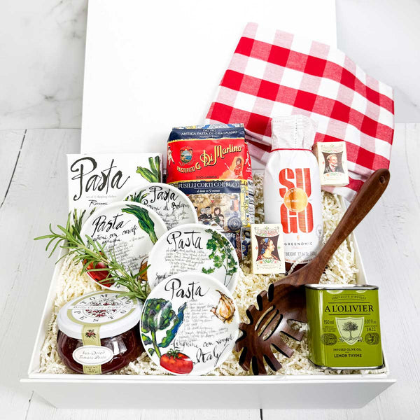 ekuBOX gift box with Italian-themed products including pasta and olive oil, pasta sauce, dipping dishes and a pasta spoon on a white background