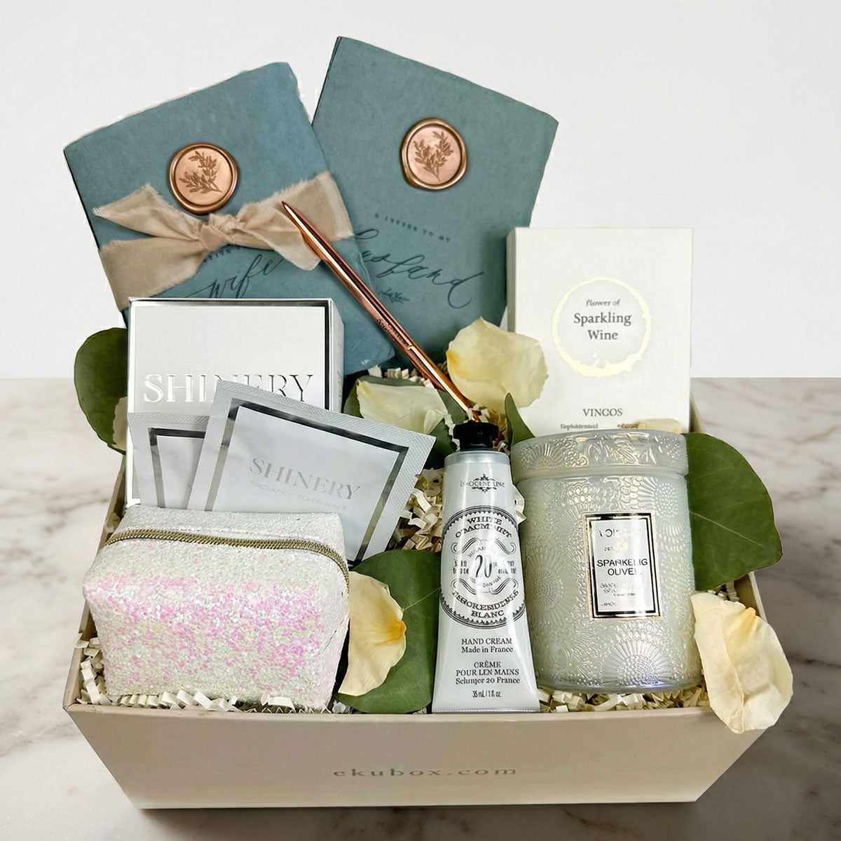 gift for bride with candle, handcream, vow booklets, gummies, pen in gift box with rose petals 