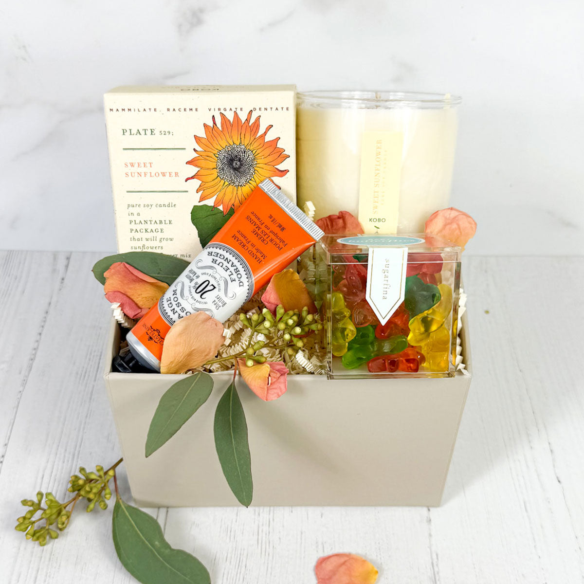 Sunflower Sweetness Surprise gift box at with a sweet sunflower candle in a plant the box, handcream and sugarfina candies
