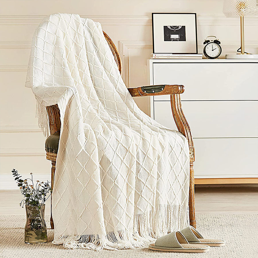 White textured throw blanket draped over a wooden chair in a room with decor elements.